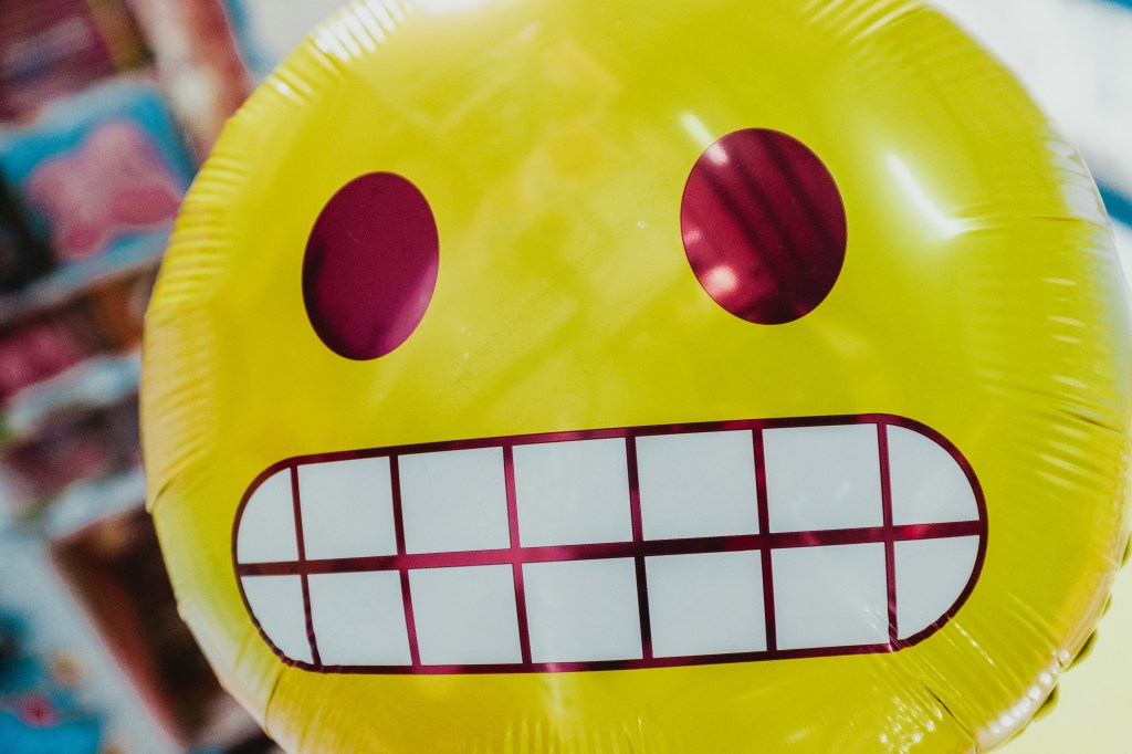 balloon depicting yellow cringe emoji face with gritted teeth